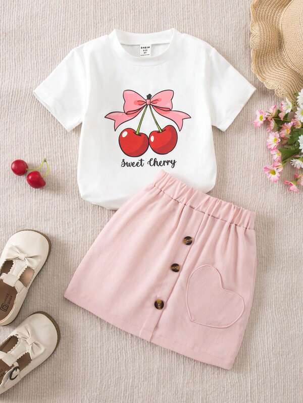 SHEIN Genkimix Kids Пролетно-летен комплект от 2 части за млади момичета, тениска и пола, тениска с къс ръкав със сладка панделка и щампа с череши, пола с джобче със сърце, ежедневен шикозен тоалет за излизания и събирания. Комплекти дрехи за момичета. Летен детски комплект с къса пола, детски тоалет с череши. Комплект от две части за момичета с череши. Сладък комплект от две части за момичета.