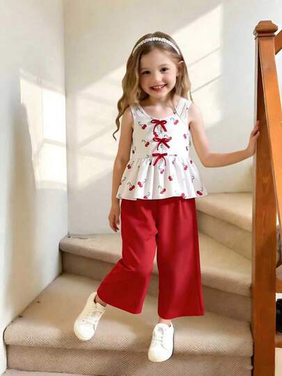 Set de 2 piezas para niñas jóvenes: Chaleco sin mangas con cuello redondo y estampado de cerezas con decoración de lazo rojo + Pantalones anchos y fluidos de pierna ancha rojos, conjunto casual dulce y juvenil para el verano