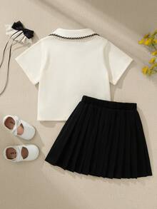 Souflis Souflis 两件套法式女童套装，白色针织短袖polo衫，撞色领口，搭配黑色百褶裙，休闲时尚，适合外出、上学等场合，4-7岁。 - 彩色 - 查看 8