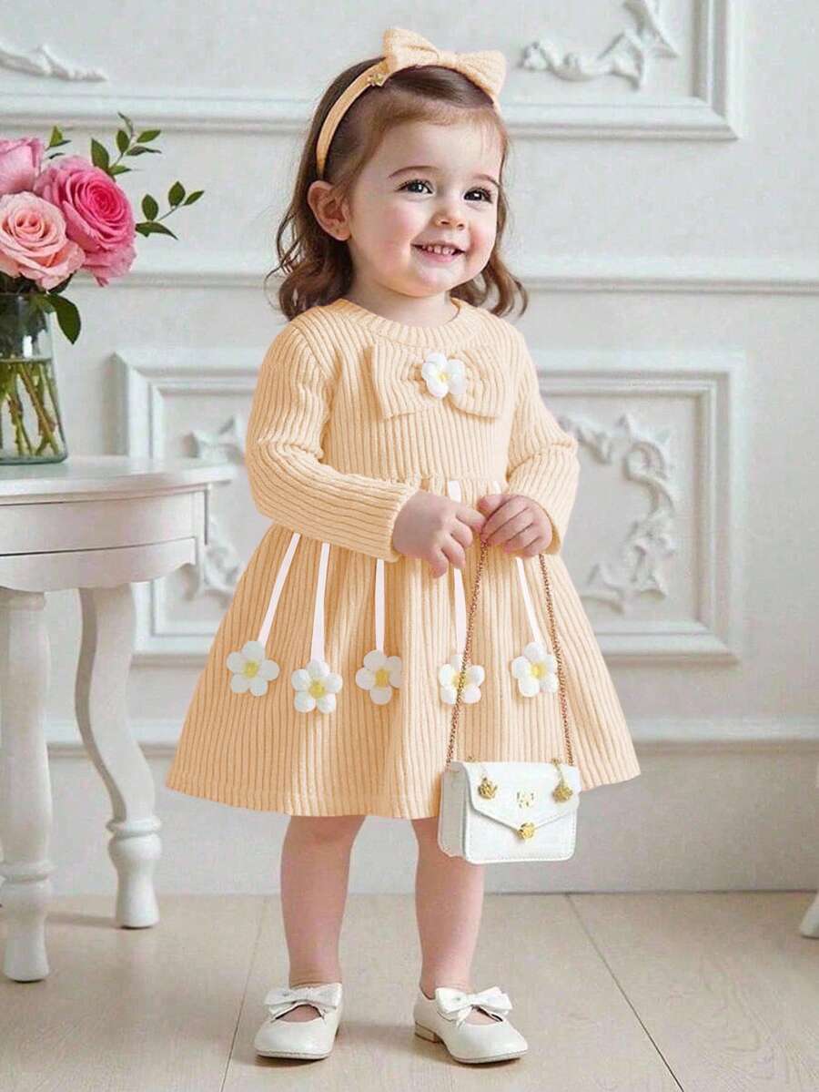 Souflis Souflis Vestido de malha canelada para bebês meninas, com gola redonda, mangas compridas e laço grande com estampa floral 3D. Lindo e delicado, perfeito para primavera/outono. Acompanha bolsinha. Vestido amarelo cor damasco para bebês meninas. Vestido bege para bebês meninas. Vestido amarelo com gola Peter Pan. Conjunto de duas peças para o verão, nova coleção primavera/outono 2026. - Amarelo - Ver 1