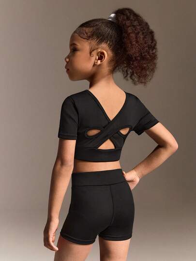 Young Girls' Back-To-School Activewear Set In Black Featuring A Short-Sleeve Top With Crisscross Open-Back Detail And Matching Shorts, Made From Soft High-Stretch Fabric For All-Day Comfort, Perfect For School Activities, Casual Sports, And Playground Fun