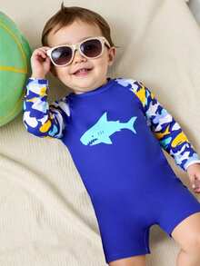 Baddräkt med dragkedja för spädbarn, tryck med haj och havsliv. Ett måste för sommarsemestern på stranden. Långärmad design, blå kontrastfärg, sött mönster med hajar och havsliv. Livlig och färgglad. Lämplig för söta pojkar att bära när de leker på stranden. - Kungsblått - Visa 1