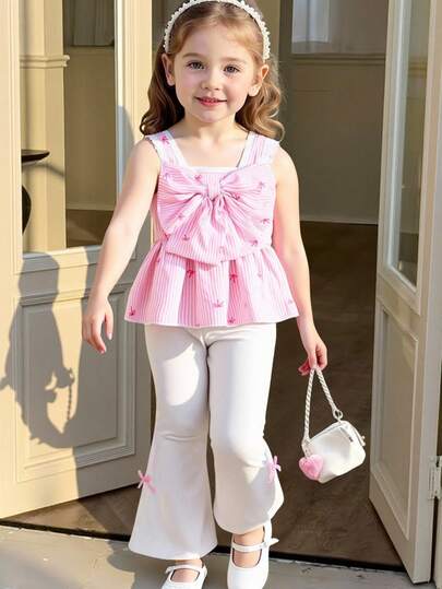 女童条纹蝴蝶结装饰印花吊带背心，宽肩带设计，搭配白色蕾丝边饰、大蝴蝶结点缀和针织喇叭裤套装。裤脚饰有2个粉色蝴蝶结，时尚优雅，适合派对和度假穿着。