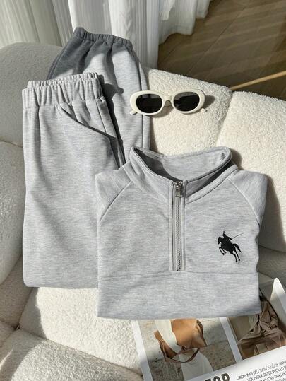 Sparklyn 这款两件套少女浅灰色简约时尚休闲运动套装，适合春秋季穿着。套装包含一件印有小马图案的立领半拉链罗纹袖口卫衣和一条松紧腰带锥形运动裤，是日常出行、运动和休闲活动的理想之选。