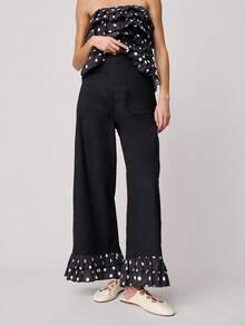 Nöista Pantalones de pierna ancha y cintura alta con bolsillos delanteros y volantes con estampado de lunares en el bajo. Estos pantalones combinan un estilo clásico con un detalle llamativo y divertido, ideales para la primavera, las vacaciones de primavera, la primavera, el estilo casual y la moda de vacaciones. - Negro - Ver 1