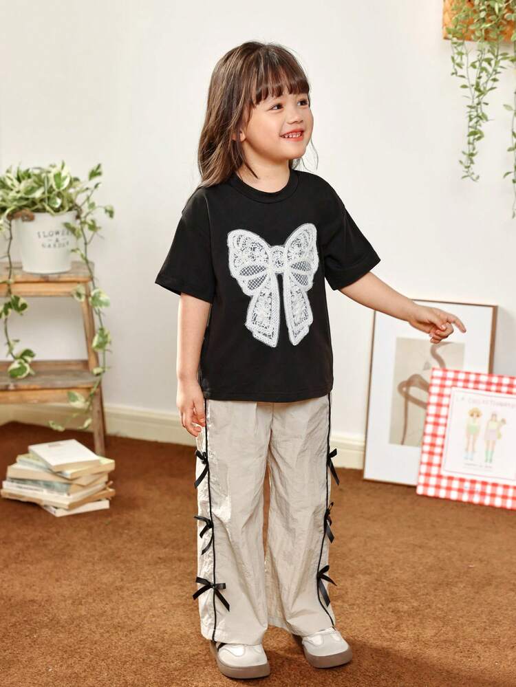 Genkimix Kids 2 st/set set med söta rundhalsade tröjor för unga flickor, broderad fjäril, kortärmade tröjor och mjukisbyxor. Kortärmat set med enkla, fina och energiska broderade rosettdekorationer, medan byxorna har accentuerade sportiga rosettdetaljer – perfekt för vår och sommar. - Multifärgad - Visa 3