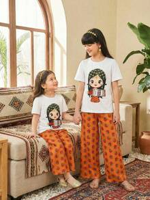 这款专为少女设计的传统阿拉伯服饰套装，包括一件印有卡通花瓶图案的短袖T恤和一条印花长裤。整体设计宽松舒适，适合各种场合和炎热天气，尽显女孩活泼可爱的气质。 - 彩色 - 查看 3