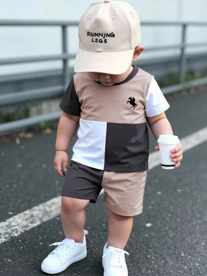 2 st/set babypojke moderiktigt minimalistiskt riddare-logotyp och färgblockstryck rund halsringning kortärmat t-shirt + matchande färgblockshorts set, lämpligt för utflykter på sommaren