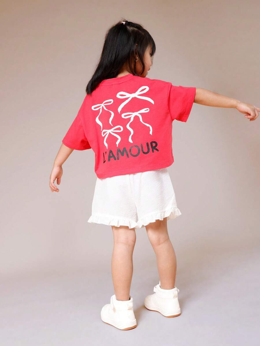 SUMWON Conjunto de verano informal de dos piezas para el Día de San Valentín con blusa corta estampada con lazo "L'Amour" y shorts blancos con volantes para niñas - Rojo - Ver 1