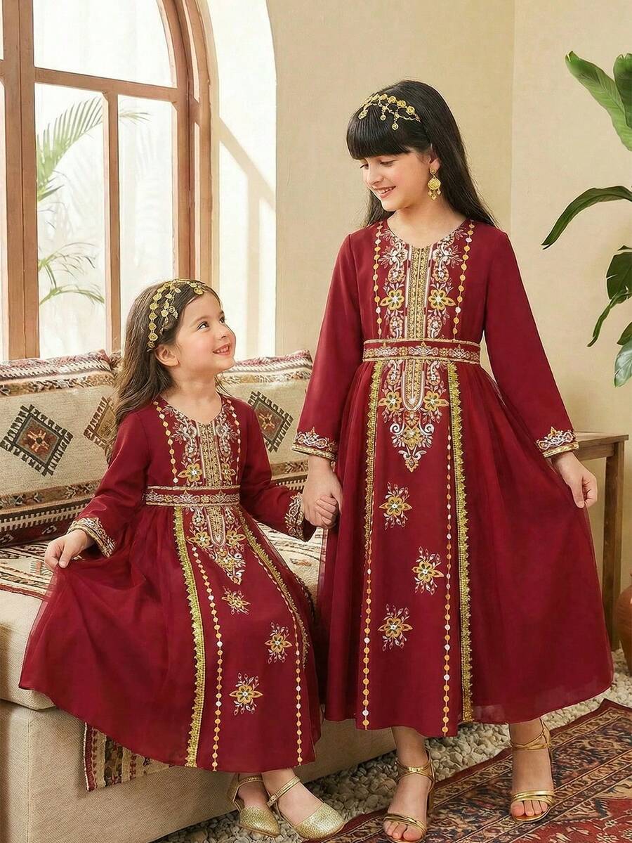 SHEIN Tween Girls' Burgundy Long Sleeve Robe. The Main Body Is Made Of Burgundy Fabric, With A Sheer Chiffon Hem That Provides A Flowing And Lightweight Feel. The Neckline, Front Placket, And Cuffs Feature Golden-Colored Printed Patterns, Decorated With Beaded Prints. A Matching Printed Belt Is Included At The Waist. The Design Combines Elements And Festive Dress Features. - Burgundy - View 1