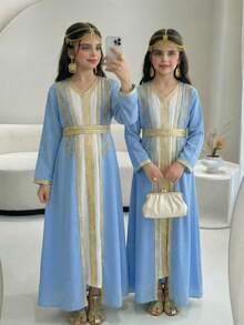 这款两件套女童套装包含一件蓝色长袍和一件白色中长V领吊带裙，风格独特，充满中东风情。套装配有可拆卸腰带，方便穿脱。这款百搭连衣裙非常适合外出穿着，既舒适又充满独特魅力。