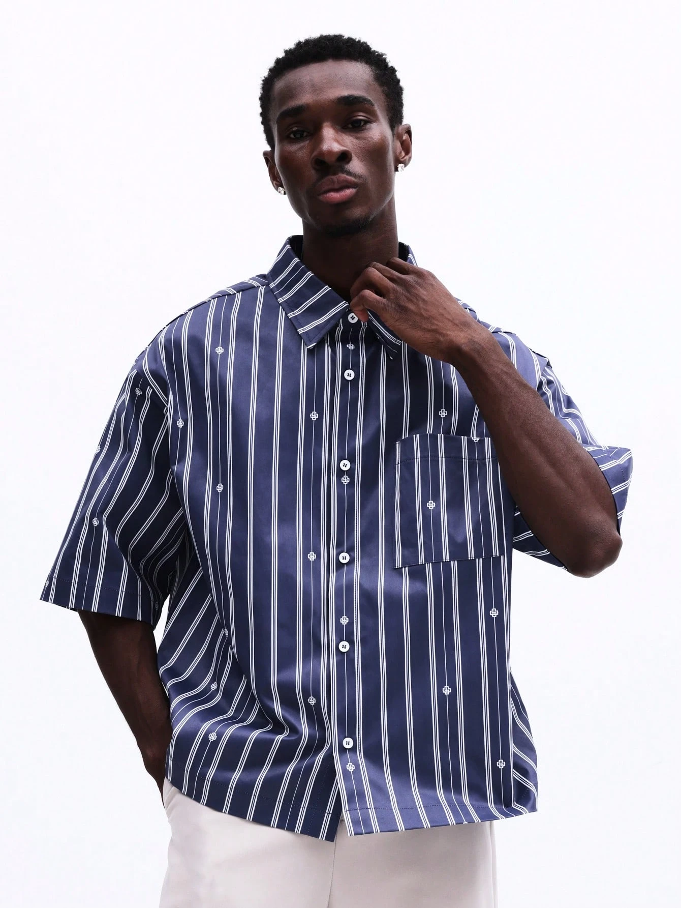 Camisa listrada oversized com botões e bolso no peito.