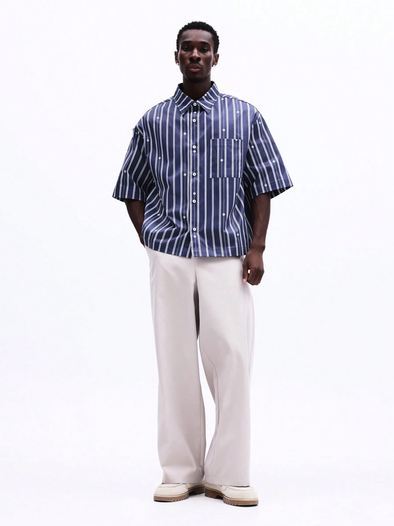 Camisa listrada oversized com botões e bolso no peito.