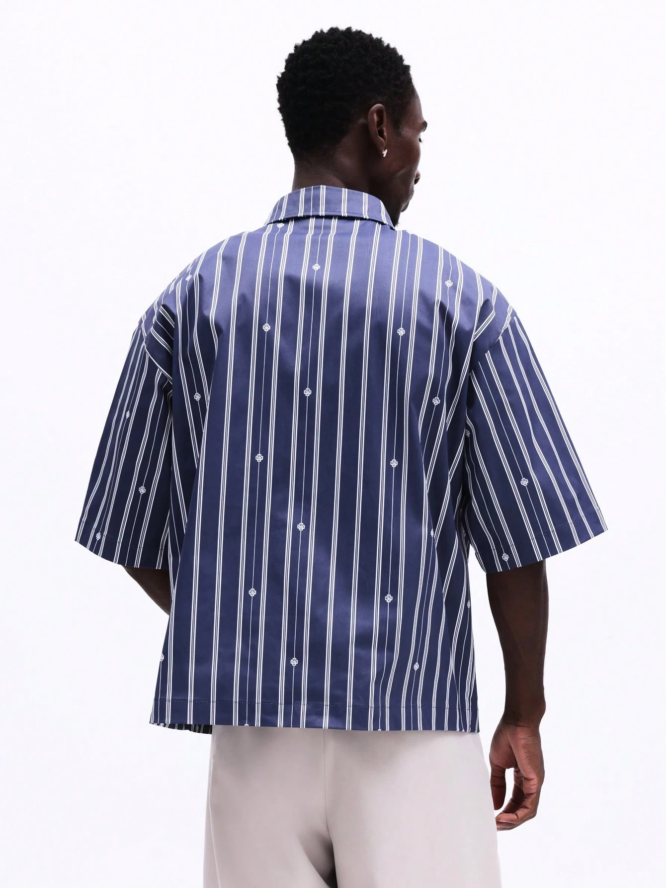 Camisa listrada oversized com botões e bolso no peito.