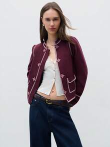 Nöista 这款外套采用优雅的复古立领和中式纽扣设计。修身的剪裁和配色，搭配对比鲜明的明线缝制，营造出和谐而又引人注目的造型。外套采用仿羊毛面料，融合了传统中式设计与现代廓形。非常适合春末夏初和初春时节穿着，搭配修身裤或半身裙，日常穿着也十分出彩。 - 中紫紅色 - 查看 4