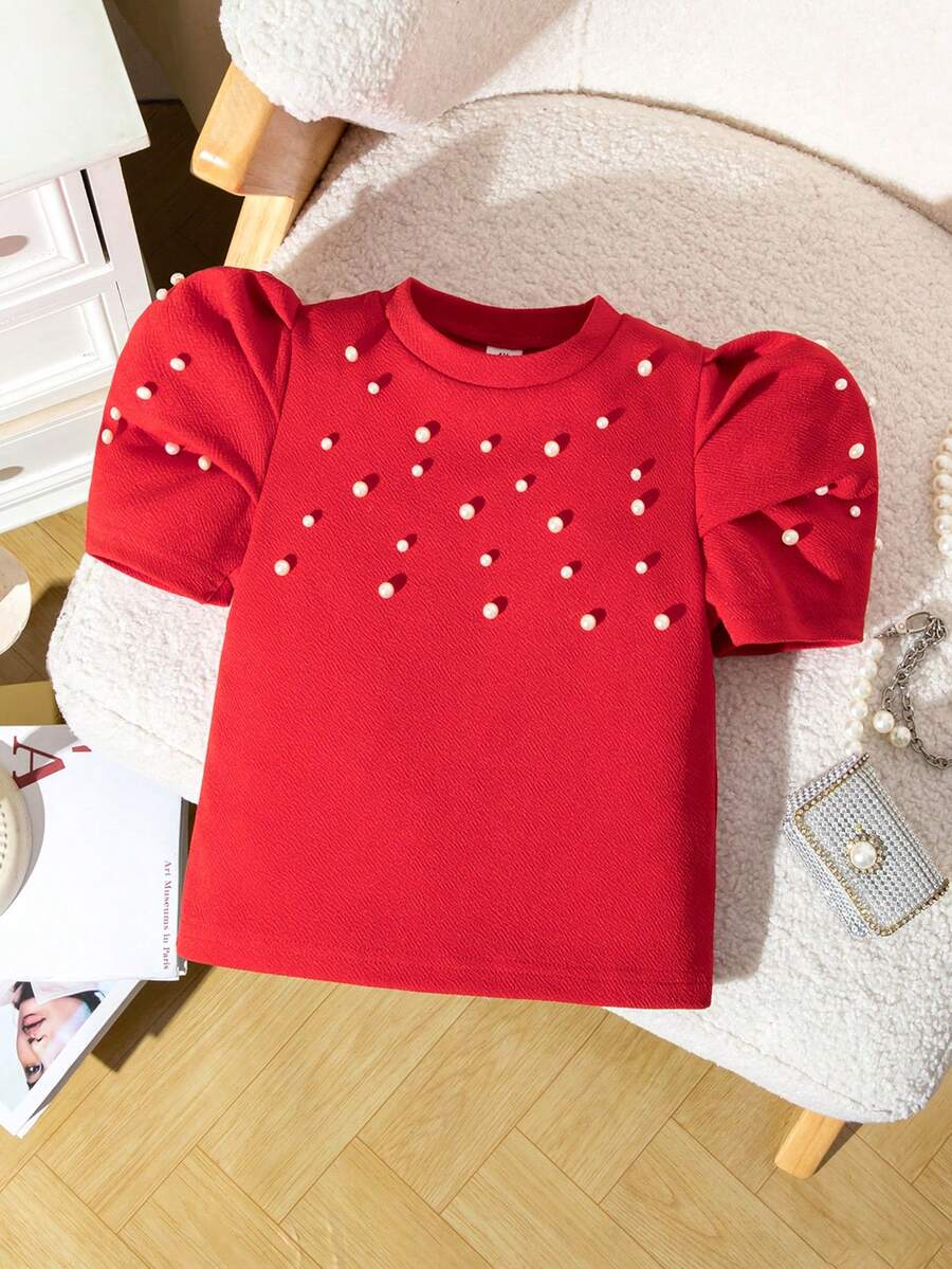 Elladie kids 这款红色短袖T恤专为小女孩设计,采用甜美的泡泡袖款式,版型挺括可爱。精致的串珠装饰更添优雅时尚气息。穿着舒适,适合夏季休闲或派对场合。鲜艳的红色让穿着者自信闪耀,散发出童真魅力。红色泡泡袖上衣,饰有仿珍珠。 - 紅色 - 查看 1