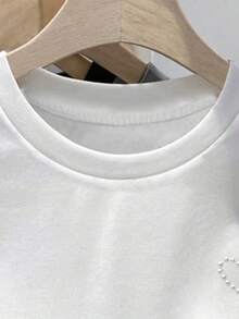 修身短款白色T恤，珍珠爱心图案，适合青少年女孩，春、夏、秋季穿着，日常休闲时尚，适合13-16岁女孩。