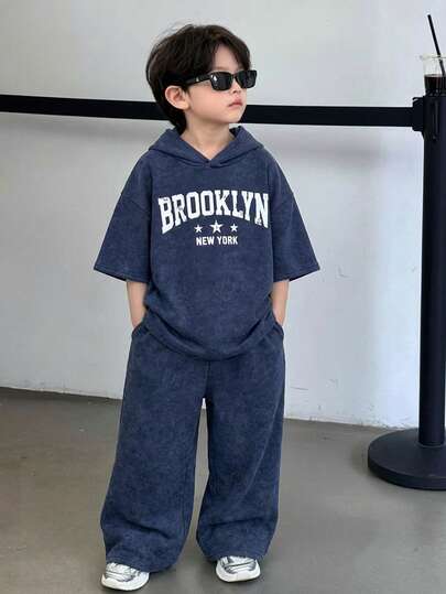 2 st barn tween pojke casual college-stil bekväm bokstavstryck huva kortärmad t-shirt och raka löst sittande mjukisbyxor träningsset, lämplig för vår/sommar, utflykter, alla hjärtans dag, dejter, resor, semestrar, familjesammankomster, tillbaka till skolan, bröllop, kvällar, sport, födelsedagsfester