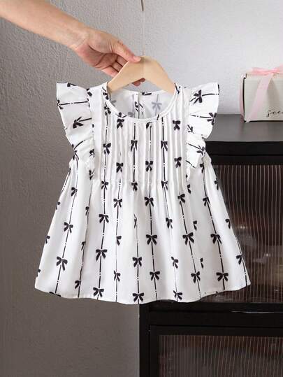 SHEIN 女童无袖短款上衣，象牙色底色上饰有黑色蝴蝶结印花，喇叭袖设计，甜美又不失酷感，前片褶裥点缀和泡泡袖肩部设计，兼具可爱与时尚，适合休闲外出、街头风和夏季穿着。