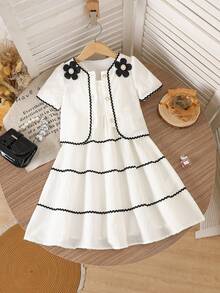 SHEIN Bộ váy hai dây màu trắng kem kiểu Pháp cổ điển dành cho bé gái, gồm váy và áo khoác cardigan tay ngắn. Váy được làm từ vải kẻ sọc dọc mềm mại, có phần gấu váy xếp tầng với viền lượn sóng màu đen. Áo khoác cardigan có cổ tròn được trang trí bằng họa tiết hoa 3D màu đen và viền lượn sóng đen. Thiết kế tổng thể tươi mới, tinh nghịch với chút ngọt ngào cổ điển. Váy nhẹ và áo khoác cardigan mỏng phù hợp cho những buổi đi chơi thường ngày, dạo chơi công viên hoặc những buổi họp mặt gia đình vào mùa hè. - trắng - Xem 7