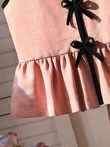 SHEIN Conjunto de 2 piezas para niñas mayores, con una blusa de tirantes rosa con botón negro y dobladillo con volantes, combinada con pantalones anchos a juego. Esta mezcla de moda combina elementos tradicionales de la ropa con comodidad moderna, adecuada para uso diario, fiestas o eventos culturales. Hecho de tela suave con un corte elegante, es una opción ideal para niñas jóvenes y a la moda. - Rosa - Ver 6