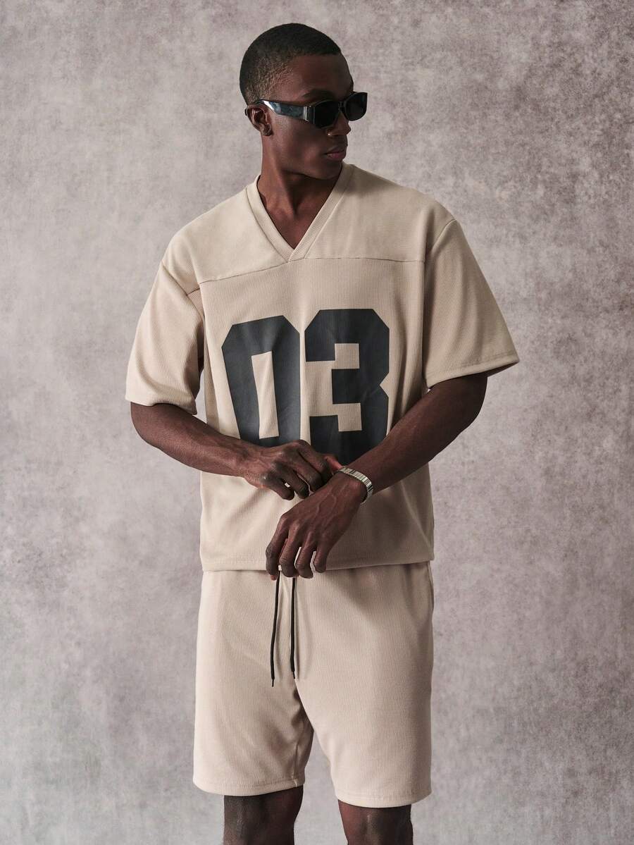 STYNVO طقم قصير الأكمام بطبعة أرقام وياقة على شكل حرف V وشورت كاجوال للرجال - كاكي - مشاهدة 1