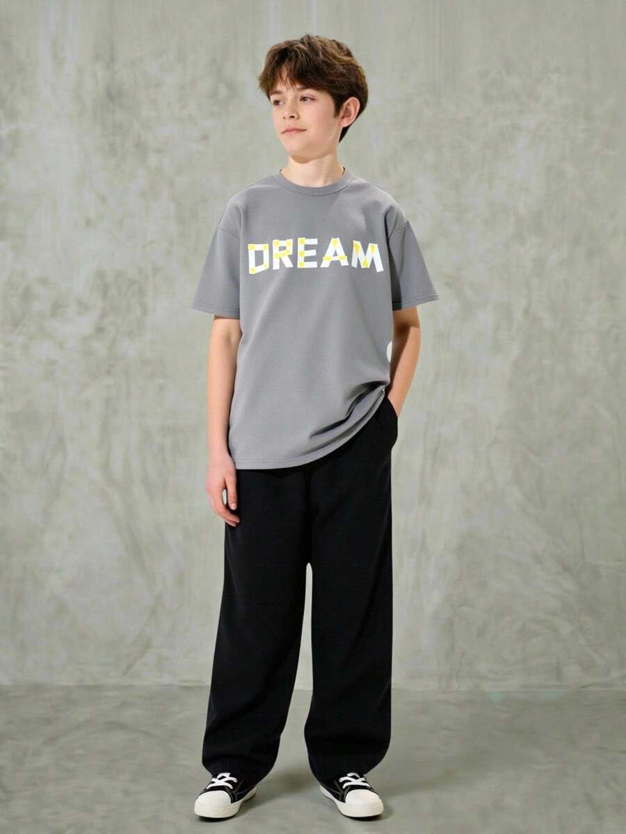 SHEIN Explorewe 两件套男童灰色宽松圆领短袖DREAM字母印花上衣搭配黑色阔腿裤,裤子采用松紧腰设计,裤腿有层次感,休闲街头风,适合夏季、街头、返校、日常穿着。 - 彩色 - 查看 1