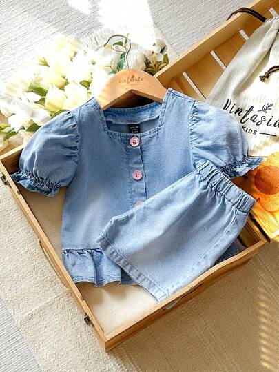 女童牛仔套装 - 宽松荷叶边袖牛仔上衣，饰有粉色纽扣，搭配宽松弹力腰牛仔短裤。采用轻盈柔软的棉质牛仔面料，是时尚女孩的必备单品。适合春夏穿着，休闲外出、拍照、参加派对等场合。秋季新品上市。