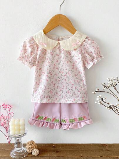 女婴碎花泡泡袖上衣搭配荷叶边短裤，活泼休闲，适合日常穿着和外出活动。