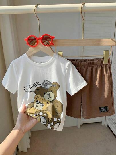 SHEIN 2件套男童休闲时尚街头宽松字母条纹印花圆领短袖T恤和纯色针织短裤套装，适合春夏季节、日常穿着、运动、郊游、上学、聚会、度假、拍照等场合。