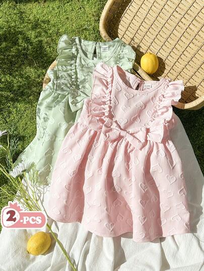 Vintaside Kids 这款女宝宝夏季情人节两件套粉色和绿色心形提花荷叶边蝴蝶结装饰圆领无袖连衣裙套装，清新、温柔、甜美，尽显公主风范。面料采用立体提花纹理，厚度适中，A字版型，适合家庭约会、校园活动、派对和休闲居家等各种场合穿着。