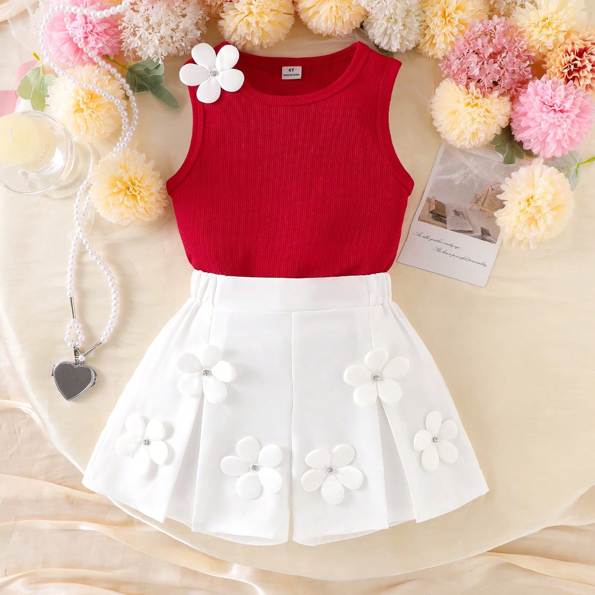 Set de 2 piezas: Chaleco sin mangas rojo tejido para niñas con flor blanca de 5 pétalos, shorts plisados beige con flor, conjunto de moda y verano