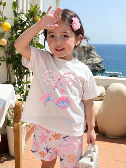 女婴可爱贝壳珍珠蝴蝶结印花套装，时尚休闲舒适圆领短袖T恤短裤套装，适合派对和聚会。甜美的珍珠蝴蝶结贝壳海星图案设计，撞色圆领T恤搭配短裤，轻盈舒适，适合春夏穿着。时尚休闲，适合街头、户外、野餐、上学、度假和送礼。