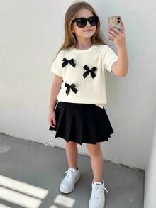两件套女童T恤裙套装，学院风，圆领短袖上衣饰有3D蝴蝶结，搭配黑色百褶裙，甜美休闲的夏季装扮 - 杏色 - 查看 7