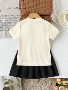 两件套女童T恤裙套装，学院风，圆领短袖上衣饰有3D蝴蝶结，搭配黑色百褶裙，甜美休闲的夏季装扮 - 杏色 - 查看 2