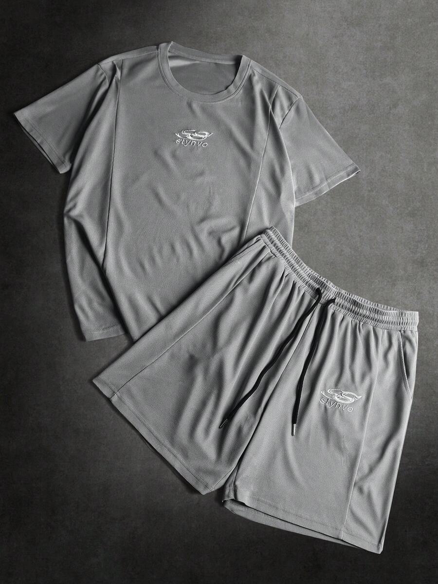 STYNVO Conjunto de camiseta de manga corta con cuello redondo y estampado gráfico, y pantalones cortos con cordón en la cintura para hombre. Conjunto casual de parte superior e inferior de 2 piezas con camiseta de manga corta con estampado gráfico y letras, y pantalones cortos para hombre. Conjunto coordinado de verano para hombre - Gris Claro - Ver 1