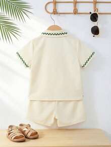 SHEIN Playful Pals 男童热带度假风夏季短袖衬衫短裤套装，包含一件立领热带度假图案上衣和一条配套的松紧腰短裤。童装。婴儿服装，婴儿上衣，婴儿短裤，婴儿套装，婴幼儿夏季套装，时尚度假风，适合6个月至3岁的宝宝。6M-3T - 杏色 - 查看 2