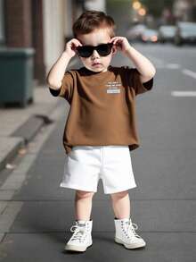 Genkimix Kids Bộ áo thun ngắn tay và quần short dáng rộng thoải mái cho bé trai, áo màu nâu, quần màu trắng phối tương phản, in khẩu hiệu tiếng Anh "ALWAYS BE YOURSELF" (Luôn là chính mình), phong cách đường phố Mỹ thời trang, thích hợp mặc hàng ngày vào mùa hè, đi học, đi chơi với bạn bè. - màu nâu - Xem 7