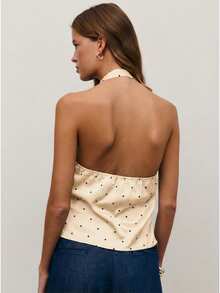 Nöista 这款缎面吊带上衣采用深V领设计，光泽棕色面料上点缀着俏皮的白色波点。它融合了复古魅力和派对时尚感，是女士冬季穿搭的理想之选，非常适合节日冬夜、圣诞晚宴或新年庆祝活动。 - 杏色 - 查看 2