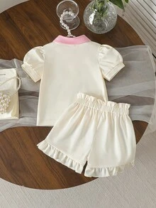 女嬰甜美粉色夏季休閒套裝 Polo領短袖T恤搭配蝴蝶結刺繡泡泡袖上衣&荷葉邊下擺短褲 奶油色 2件組 - 杏色 - 查看 3