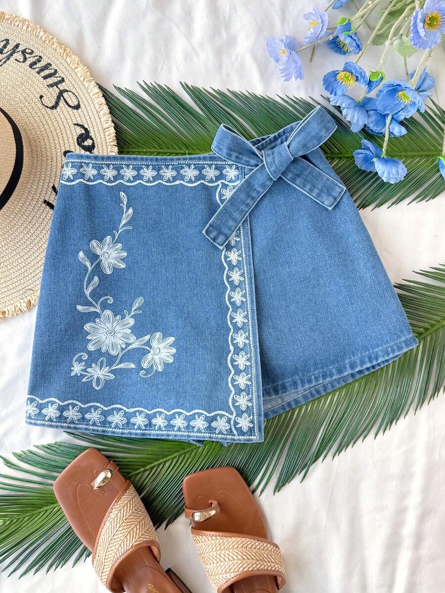 Soleia Women's Floral Print Wrap Tie Casual Denim Mini Skort Women's Mid-Blue Denim Skort With White Floral Embroidery And Bow Side Detail Summer Casual A-Line Mini Skort Summer Outfits Summer Outfits For Women Spring Clothing Spring Break Outfits Summer Holiday Outfits Summer Vacation Outfits Beach Vacation Outfits For Women Casual Outfit For Women  Floral Skort Blue Skort - Medium Wash - View 1