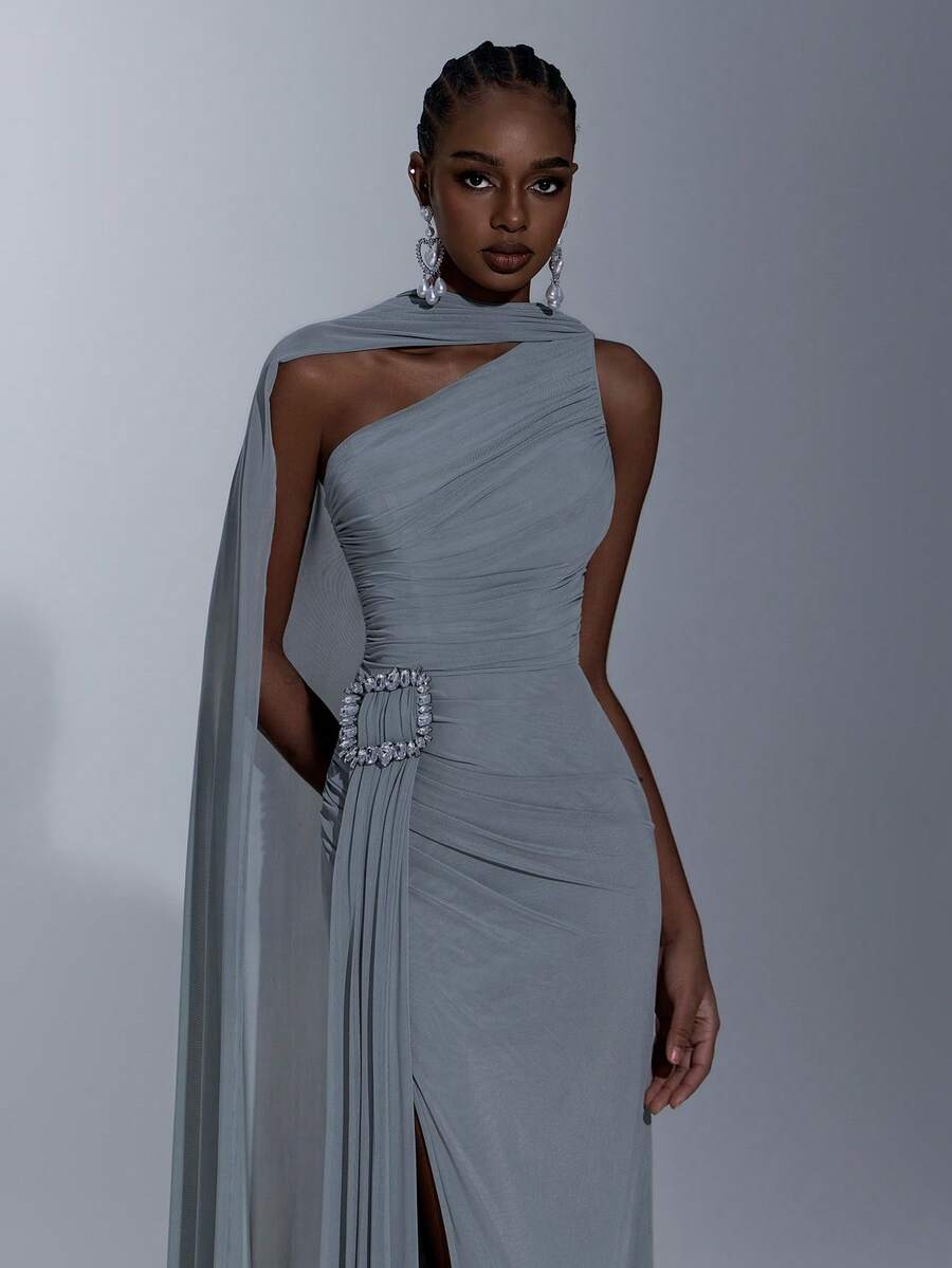 Elitara Đầm maxi dáng suông, màu xám xanh nhạt thanh lịch, chất liệu lưới co giãn cao cấp, thiết kế bất đối xứng vai, xếp ly phía trước, điểm nhấn là những chiếc cúc đính pha lê sang trọng, chân đầm xòe bồng bềnh kiểu đuôi cá, phù hợp cho các buổi hẹn hò, tiệc độc thân, đám cưới và mọi dịp trang trọng. - Xám Xanh - Xem 1