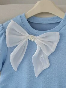 Vestido de una pieza para niña preadolescente de estilo preppy a la moda y casual, de tela de jacquard de punto elástico de color azul con cuello redondo, manga corta, con un lazo de perla blanca contrastante en la parte delantera, dobladillo plisado y mangas abullonadas. Adecuado para salidas diarias, la escuela, vacaciones al aire libre y otras ocasiones, y se puede usar en primavera y verano. - Azul - Ver 8