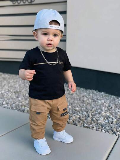 Conjunto informal de 2 piezas de bebé niño con camiseta de manga corta holgada con estampado de letras y pantalones con bolsillos grandes, adecuado para primavera, verano y otoño