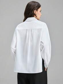 Camisa de manga comprida com cintura marcada e modelagem flare, gola boneca, coleção Primavera/Verão 2026. Ideal para festas urbanas modernas, volta às aulas, uso casual minimalista urbano, estilo boêmio, férias, festivais, primavera, Dia dos Namorados, carnaval e festas na praia. Elegante e perfeita para ocasiões especiais. - Branco - Ver 3