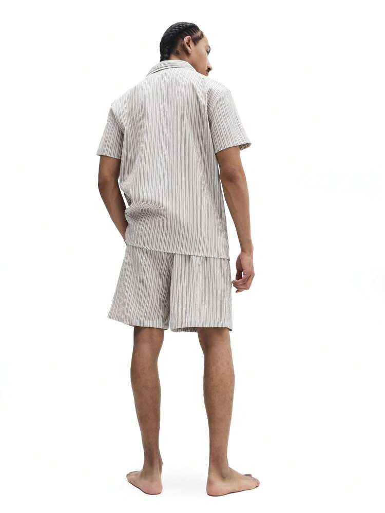 Camisa de pijama listrada de manga curta com shorts combinando.
