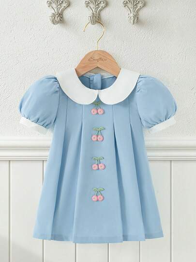Souflis Souflis 法式新款浅蓝色女婴泡泡袖双层彼得潘领A字连衣裙。饰以小樱桃图案，采用优质面料，A字廓形。泡泡袖和双层彼得潘领设计增添了一丝俏皮可爱。无论是日常穿着还是特殊场合，都能让您的宝宝成为众人瞩目的焦点，是宝宝衣橱中不可或缺的时尚单品。