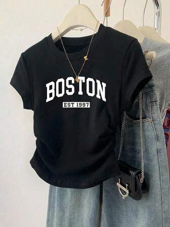 T-shirts voor tienermeisjes: aansluitend T-shirt met Engelse letterprint en elegante stijl, Europees en Amerikaans model, effen zwart, ronde hals, korte mouwen en geplooide taille.