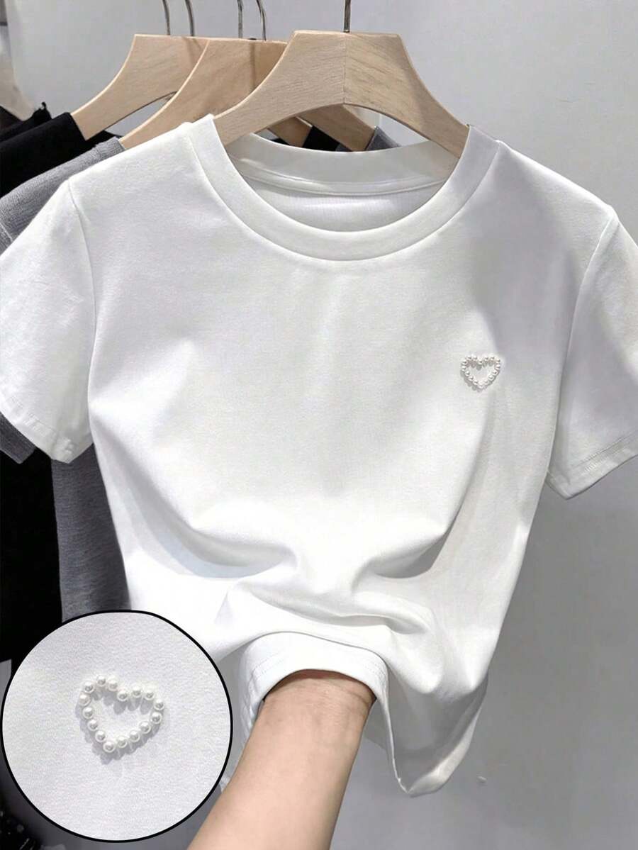 SHEIN Áo thun dệt kim màu trắng dáng rộng cổ tròn họa tiết trái tim đính hạt cườm thanh lịch đa năng thoải mái cho bé gái tuổi teen, thích hợp cho mùa xuân/hè. - trắng - Xem 1