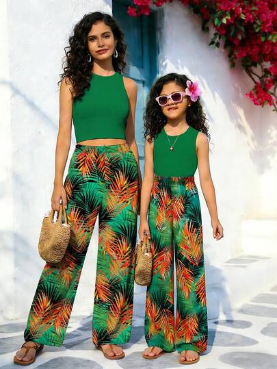 一套女童宽松热带棕榈叶印花吊带背心和阔腿裤套装，舒适时尚，适合度假穿着